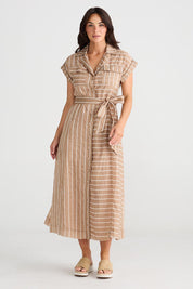 A model wearing the Portia Dress in colour Lattestrip, from the front, showing the whole outfit