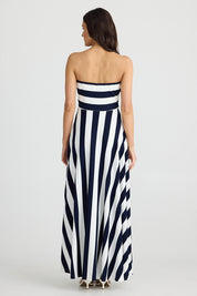 A model wearing the Thandie Strapless Dress in colour Navystripe (Blue), from the back