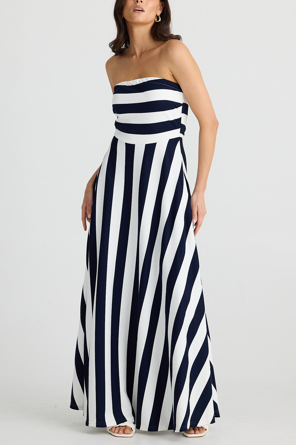 A model wearing the Thandie Strapless Dress in colour Navystripe (Blue), from the front, cropped image