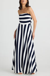 A model wearing the Thandie Strapless Dress in colour Navystripe (Blue), from the front, cropped image