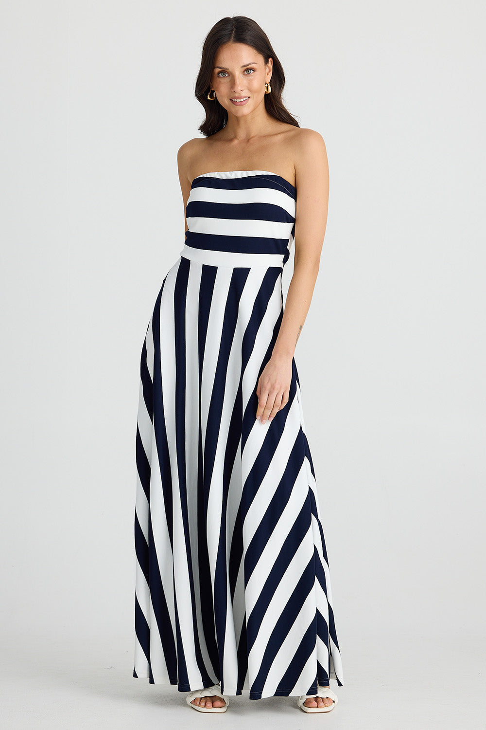 A model wearing the Thandie Strapless Dress in colour Navystripe (Blue), from the front, showing the whole outfit