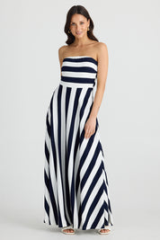 A model wearing the Thandie Strapless Dress in colour Navystripe (Blue), from the front, showing the whole outfit