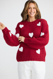 A model wearing the Heart On My Sleeve Knit in colour Cherrywhit (Red), from the front, cropped image