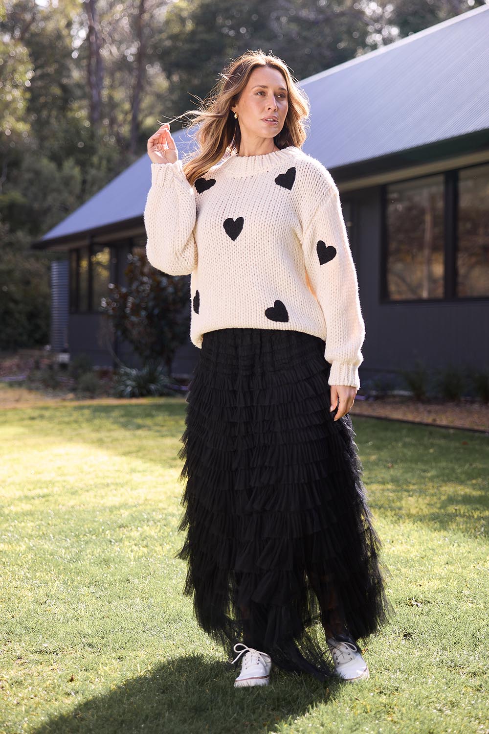 A model wearing the Heart On My Sleeve Knit in colour Offwhite (White), from the front, showing the whole outfit