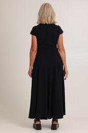 Model Sandy wearing size S of the Sylvie Cotton Dress in colour Black (Black), from the back