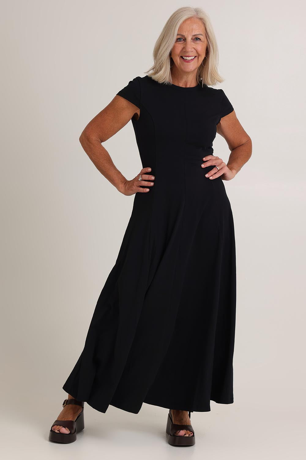 Model Sandy wearing size S of the Sylvie Cotton Dress in colour Black (Black), from the front, showing the whole outfit