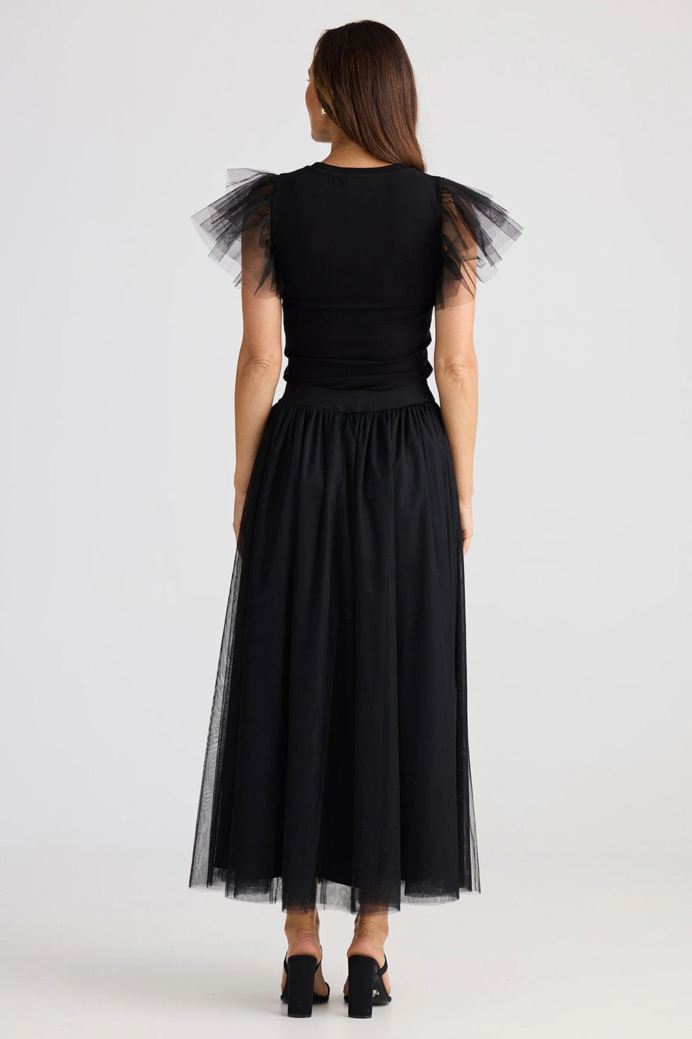 A model wearing the Carrie Skirt in colour Black (Black), from the back
