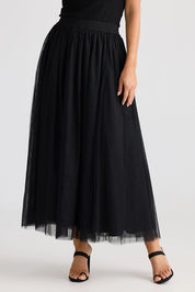 A model wearing the Carrie Skirt in colour Black (Black), from the front, cropped image