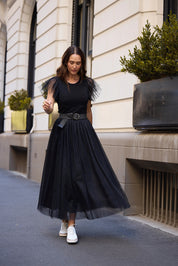 A model wearing the Carrie Skirt in colour Black (Black), from the front, showing the whole outfit
