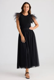 A model wearing the Carrie Skirt in colour Black (Black), from the front, showing the whole outfit