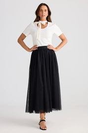 A model wearing the Carrie Skirt in colour Black (Black), from the front, showing the whole outfit