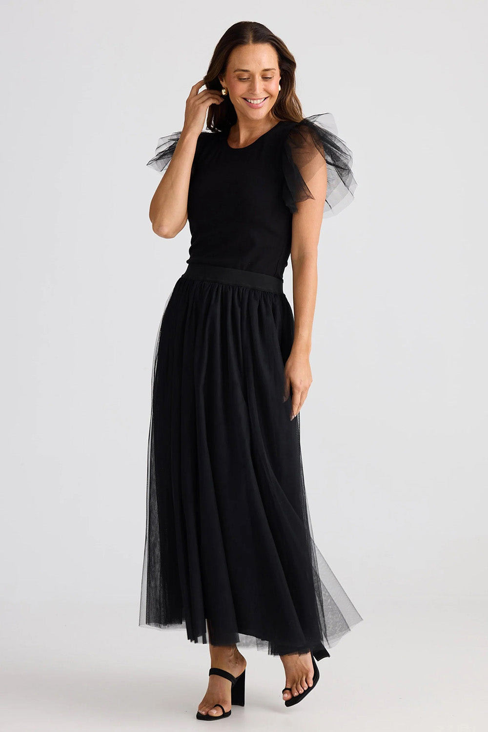 A model wearing the Carrie Skirt in colour Black (Black), from the front, showing the whole outfit