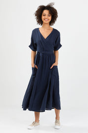 A model wearing the Pansies Wrap Dress in colour Navy (Blue), from the front, showing the whole outfit