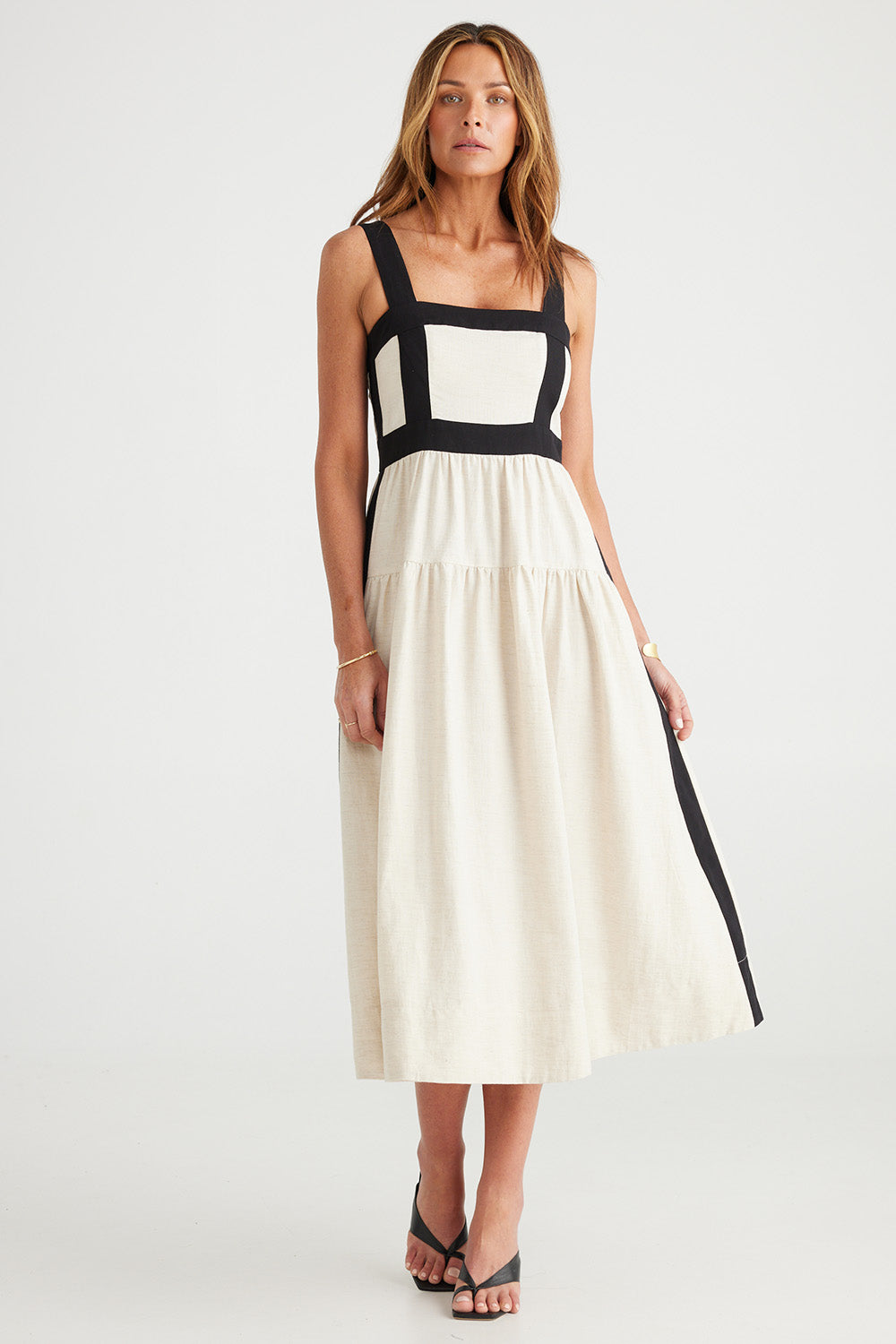 A model wearing the Jolie Dress in colour Naturalblk, from the front, showing the whole outfit