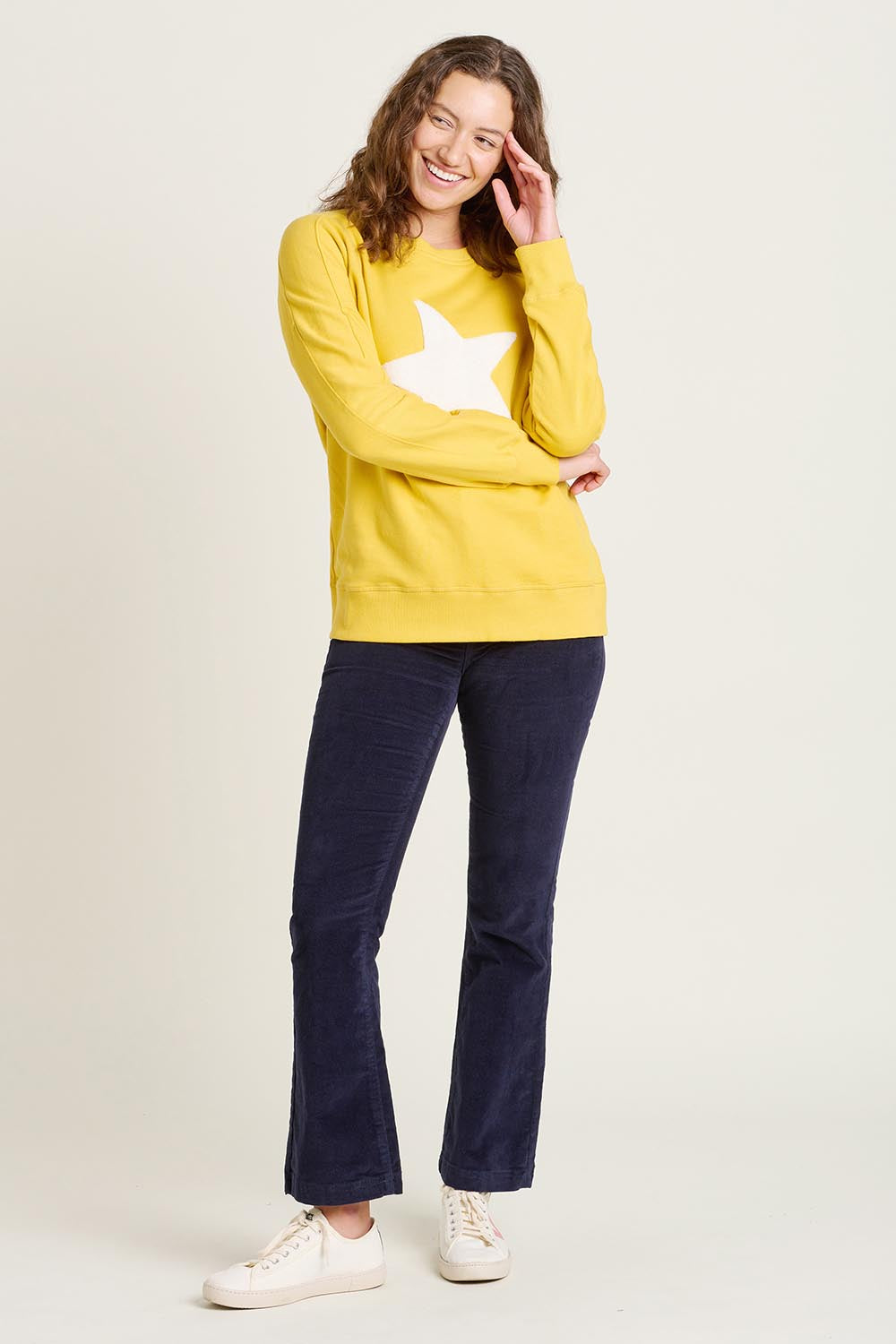 A model wearing the Star Crew Neck Cotton Sweatshirt in colour Mustard, from the front, showing the whole outfit
