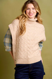 A model wearing the Cable Knitted Vest in colour Natural, from the front, showing the whole outfit