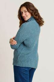 A model wearing the Cable Knitted Roll Neck Jumper in colour Blue (Blue), from the back
