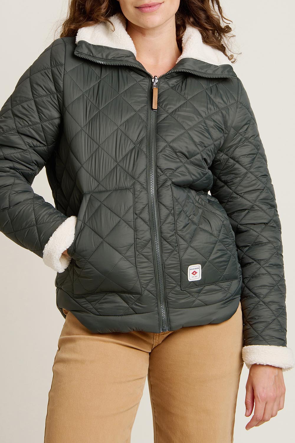 A model wearing the Fortunes Reversible Jacket in colour Multi (Green), from the front, cropped image