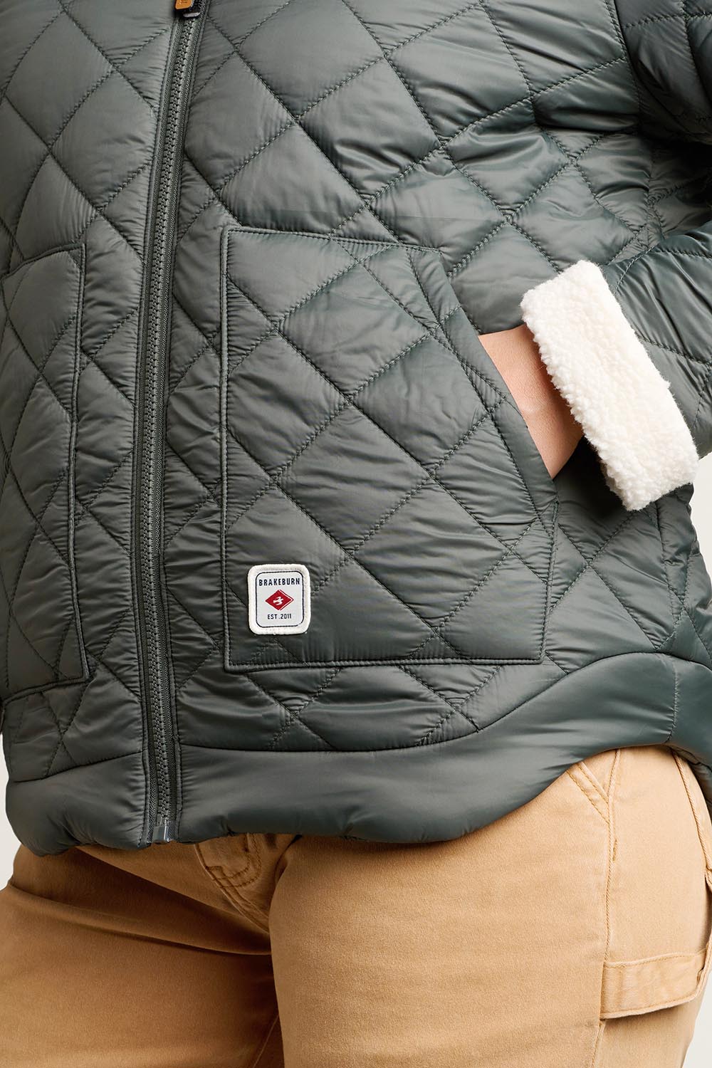 A model wearing the Fortunes Reversible Jacket in colour Multi (Green), from the front, cropped image