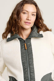 A model wearing the Fortunes Reversible Jacket in colour Multi (Green), from the front, cropped image