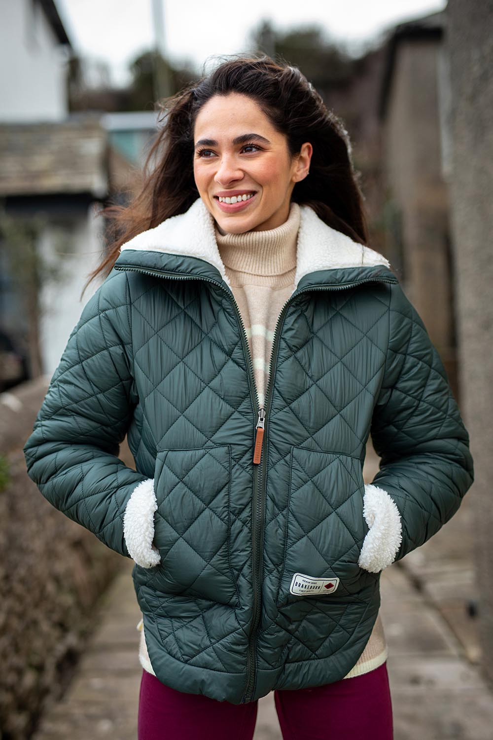 A model wearing the Fortunes Reversible Jacket in colour Multi (Green), from the front, showing the whole outfit