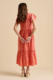 A model wearing the Sundown Cotton Maxi Dress in colour Coral, from the back