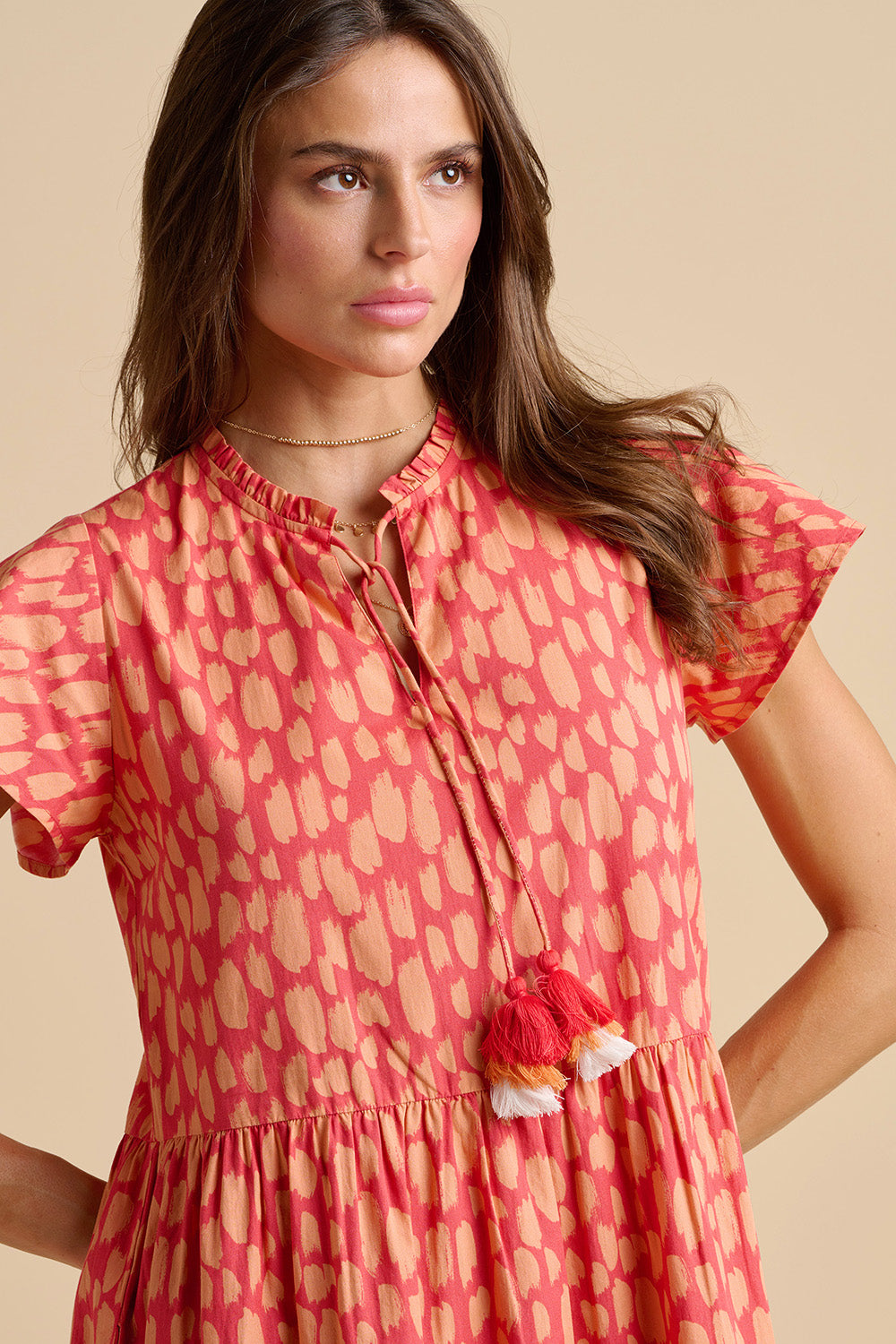 A model wearing the Sundown Cotton Maxi Dress in colour Coral, from the front, cropped image