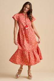 A model wearing the Sundown Cotton Maxi Dress in colour Coral, from the front, showing the whole outfit