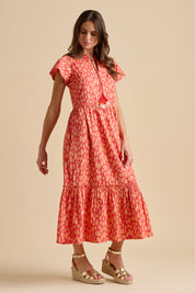 A model wearing the Sundown Cotton Maxi Dress in colour Coral, from the front, showing the whole outfit