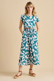 A model wearing the Woodland Leaves Maxi Cotton Jersey Dress in colour Multi (Blue), from the front, showing the whole outfit