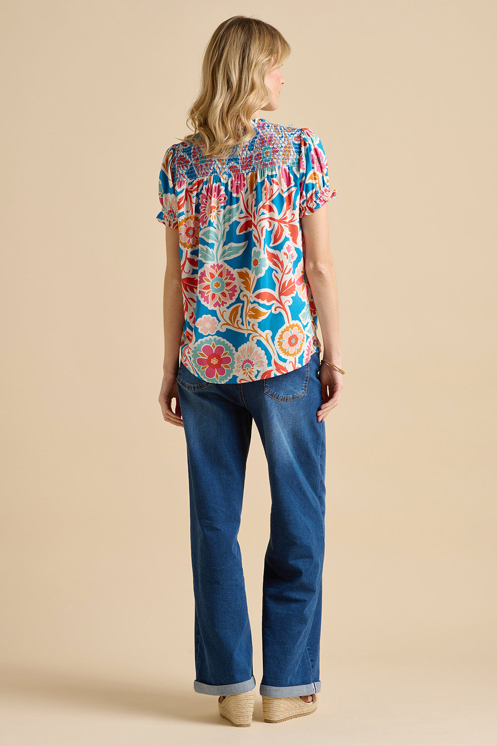 A model wearing the Full Bloom Blouse in colour Multi (Blue), from the back