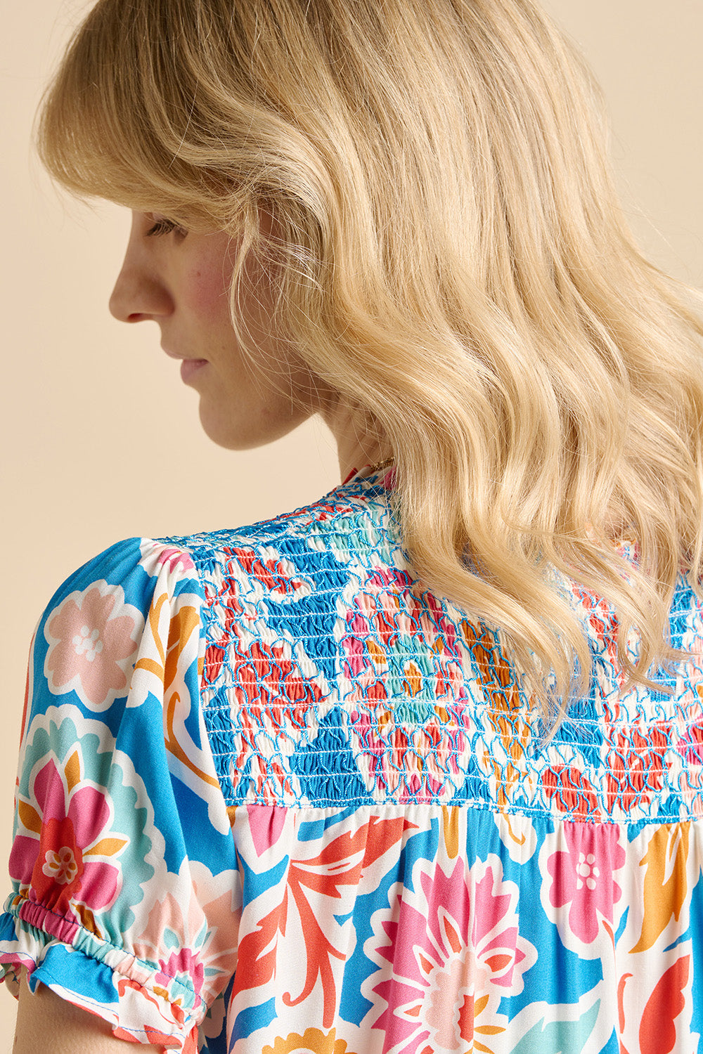 A model wearing the Full Bloom Blouse in colour Multi (Blue), from the back