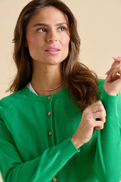 A model wearing the Kelly Green Classic Cotton Cardigan in colour Green (Green), from the front, cropped image