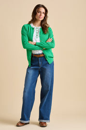 A model wearing the Kelly Green Classic Cotton Cardigan in colour Green (Green), from the front, showing the whole outfit