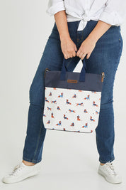 Model Tahlecia wearing size OneSize of the Sausage Dog Tote Bag in colour Creamnavy, from the front, cropped image