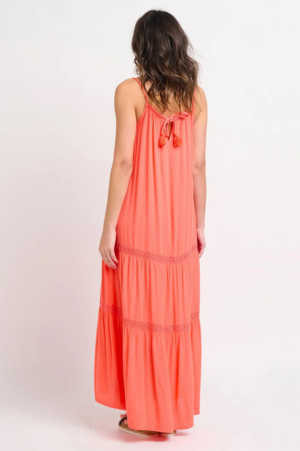 A model wearing the Amara Maxi Dress in colour Coral (Pink), from the back