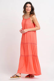 A model wearing the Amara Maxi Dress in colour Coral (Pink), from the front, showing the whole outfit