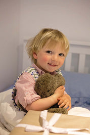 A model wearing the Baby Flatout Bear in colour Latte, from the front, showing the whole outfit
