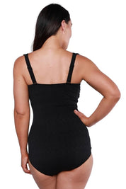 A model wearing the Classique Retro Skirted One Piece in colour Black (Black), from the back