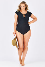 Model Jess wearing size 12 of the Short Sleeve Tie One Piece in colour Black (Black), from the front, showing the whole outfit