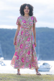 A model wearing the Bloss Silk Blend Wrap Dress in colour Bloss (Pink), from the front, showing the whole outfit