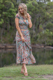 A model wearing the Eden Wrap Skirt in colour Eden (Blue), from the front, showing the whole outfit