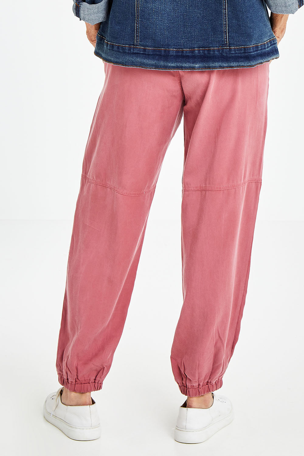 Model Elise wearing size S of the Lyocell Pant in colour Rose (Pink), from the back