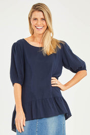 Model Kelly wearing size S of the Linen Blend Ruffle Hem Top in colour Navy (Blue), from the front, cropped image