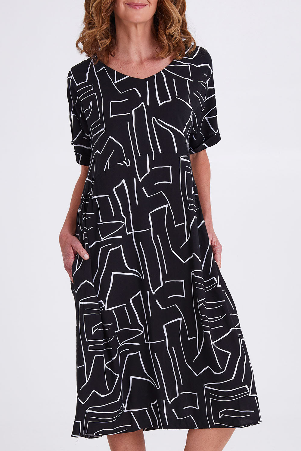 Model Emma wearing size S of the Empire Dress in colour Black (Black), from the front, cropped image