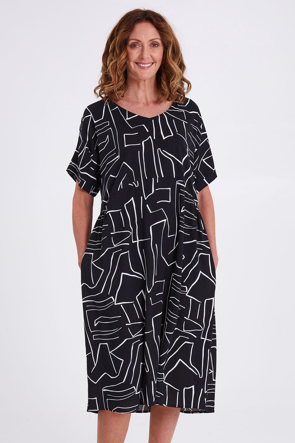 Model Emma wearing size S of the Empire Dress in colour Black (Black), from the front, cropped image