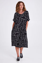 Model Emma wearing size S of the Empire Dress in colour Black (Black), from the front, showing the whole outfit