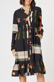 A model wearing the Galleria Dress in colour Black (Black), from the front, cropped image