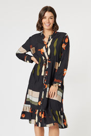 A model wearing the Galleria Dress in colour Black (Black), from the front, cropped image