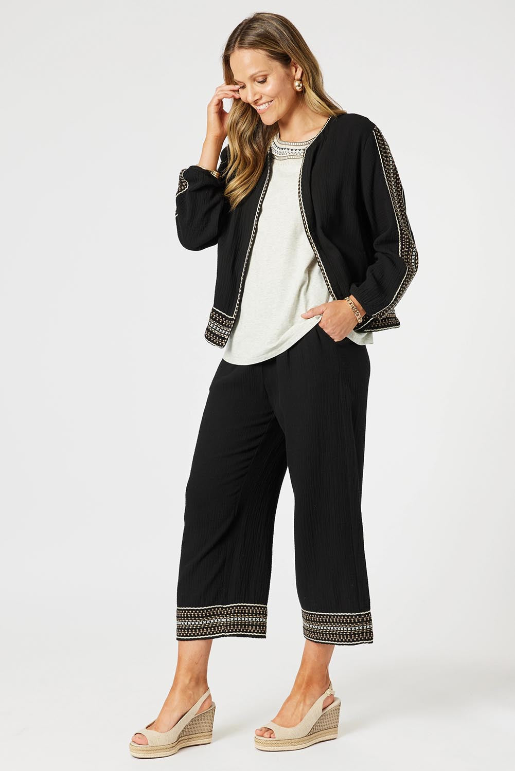 A model wearing the Cross Stitch Cotton Pant in colour Black (Black), from the front, showing the whole outfit